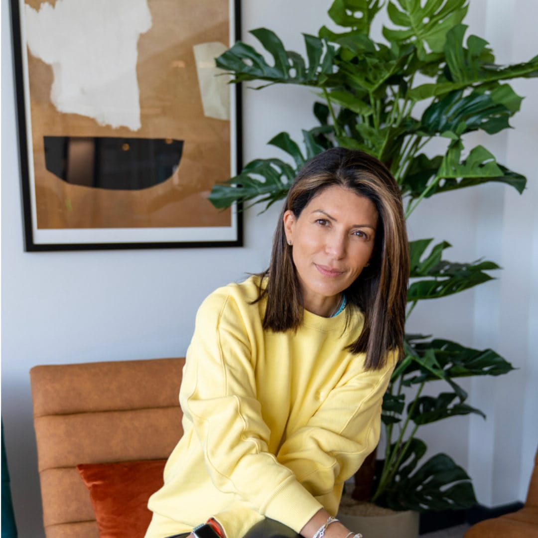 Lady in a yellow jumper smiling at the camera